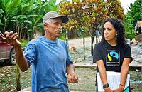 Bild vergrößern: Zu sehen ist ein Arbeiter einer Plantage mit einer Fairtrade-Mitarbeiterin